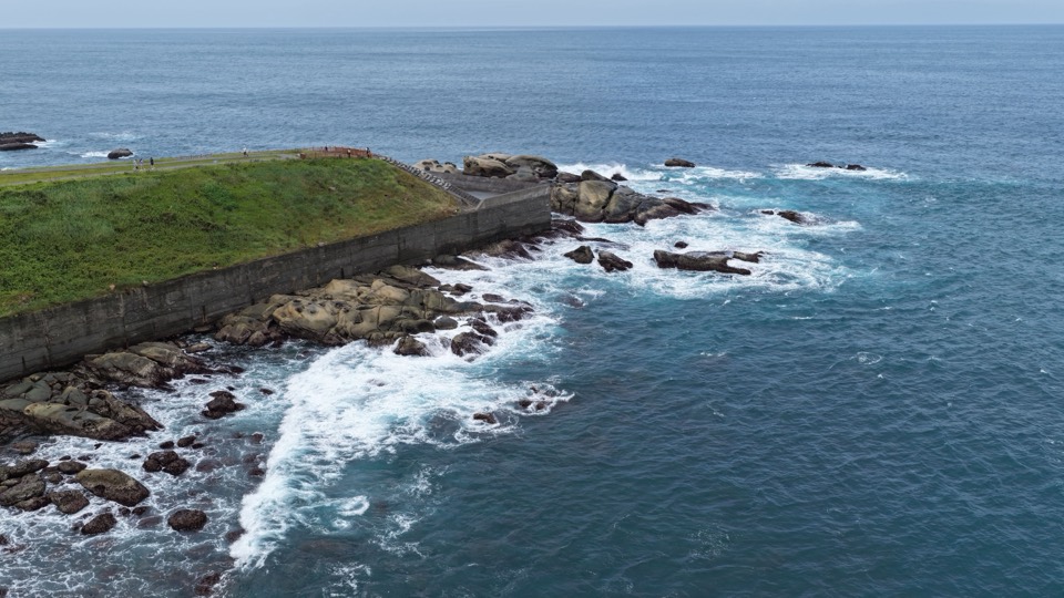 自岬角望向海面的海岸线，海平线横贯画面上缘